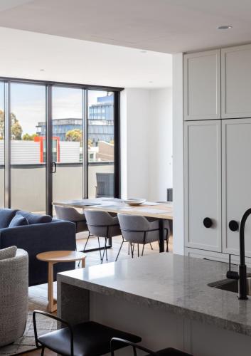 a living room with a table and chairs at Caroline Serviced Apartments Richmond in Melbourne