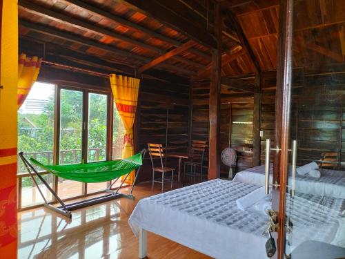 um quarto com uma cama e uma rede de descanso em FOREST BREATH ECO-LODGE em Tân Phú