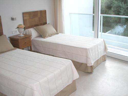 1 dormitorio con 2 camas y ventana en Villa Cel, en Cala en Blanes