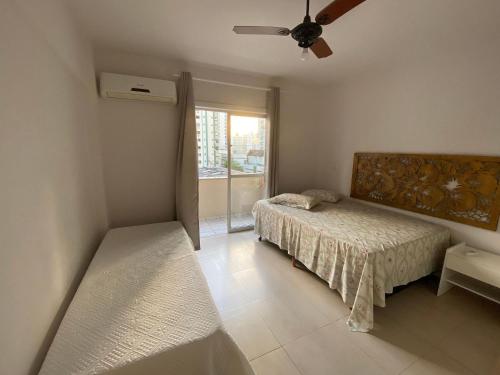 1 dormitorio con 1 cama y ventilador de techo en Apartamento Avenida Brasil, en Balneário Camboriú