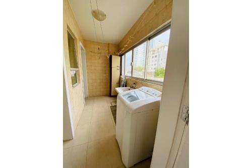 y baño con lavabo y lavadora. en Apartamento Avenida Brasil, en Balneário Camboriú