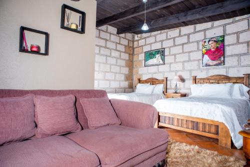 a living room with a couch and two beds at Rancho los olivos Habitaciones Campestres in San Miguel de Allende