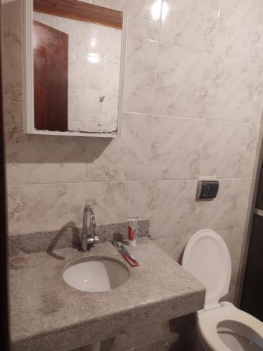 a bathroom with a sink and a toilet and a mirror at Casa Pereira Visconde de Mauá in Visconde De Maua