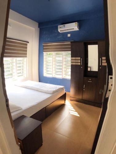 a small room with a bed and a blue wall at Royal residency in Tindummal