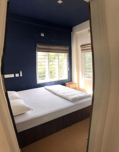 a bedroom with a bed with a blue wall at Royal residency in Tindummal