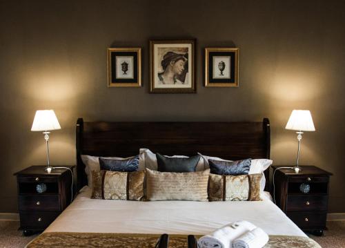 Bloemfontein的住宿－奧特斯莫旅館，一间卧室配有一张带2个床头柜和2盏灯的床。