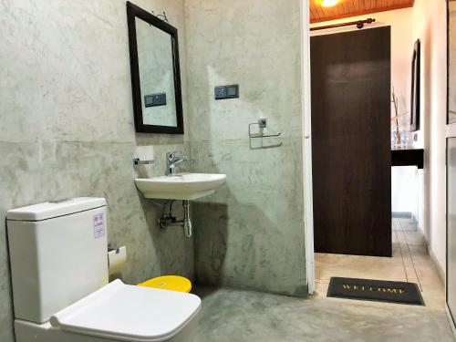 a bathroom with a toilet and a sink at Sunflower Beach Resort in Beruwala