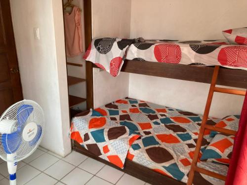 1 dormitorio con 2 literas y ventilador en Tonsupa A 2 cuadras Del Mar Parqueo Cocina Piscina Reserva con anticipo en Tonsupa