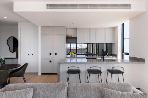 a living room with a couch and a kitchen at Caroline Serviced Apartments Richmond in Melbourne