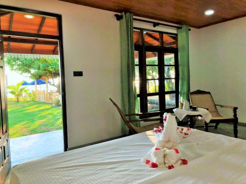 a bedroom with a bed and a view of a patio at Sunflower Beach Resort in Beruwala