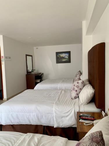 a hotel room with two beds and a table at Hotel Patrimonial by Greenfield in Guayaquil