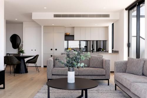 a living room with two couches and a table at Caroline Serviced Apartments Richmond in Melbourne