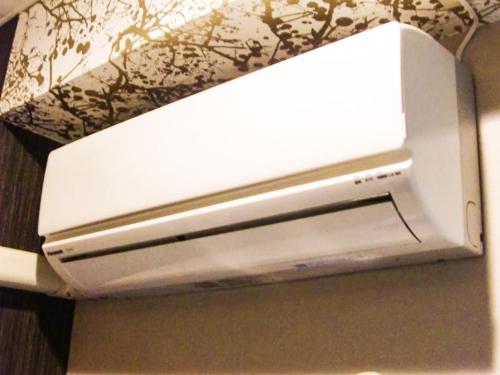a white television sitting on top of a wall at Hotel Abest Shin-Anjo-Ekimae in Anjo