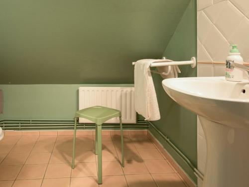ein grünes Bad mit einem Stuhl neben einem Waschbecken in der Unterkunft Gîte Le Lardin-Saint-Lazare, 4 pièces, 6 personnes - FR-1-616-220 in Saint-Lazare
