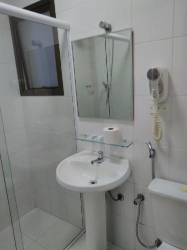 uma casa de banho com um lavatório, um chuveiro e um espelho. em Hotel Paris em São Paulo