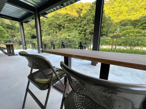 a table and chairs on a patio with a view at Sla Ulay Backpacker Hostel in Wulai
