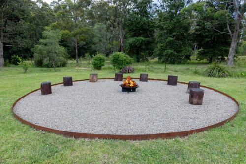 a fire pit in the middle of a circle of gravel at Cedar House in Kangaroo Valley