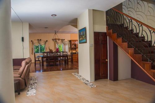 a living room with a staircase and a dining room at RunAway to Tranquility, overlooking the Bay in Runaway Bay