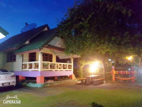 une maison la nuit avec une table devant elle dans l'établissement บ้านสุขกมลแววดาวบ้านเดี่ยว1ห้องนอน, à Ban Pak Nam