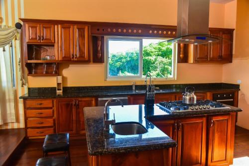 a kitchen with wooden cabinets and a sink and a window at RunAway to Tranquility, overlooking the Bay in Runaway Bay