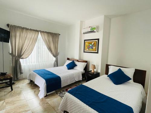 1 Schlafzimmer mit 2 Betten und einem Fenster in der Unterkunft Apartahotel Casa Soleil in Puerto Villamil