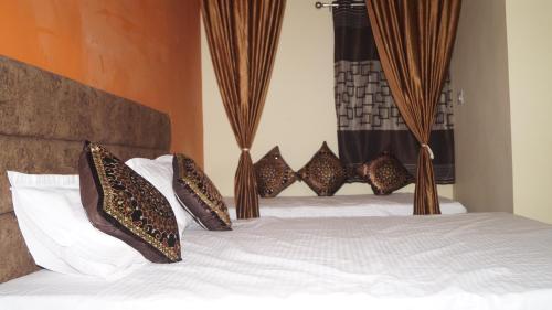 a bedroom with a bed with pillows on it at K & K Hotel in Jabalpur