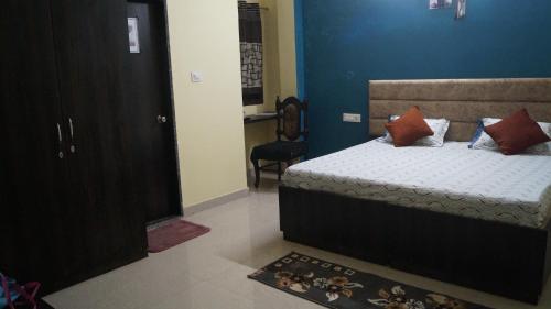 a bedroom with a bed and a blue wall at K & K Hotel in Jabalpur