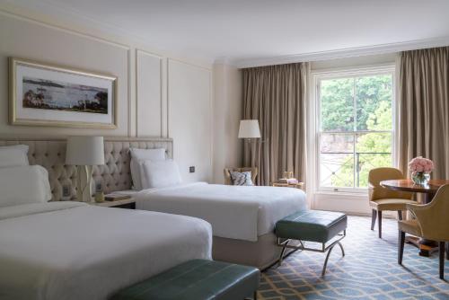 a hotel room with two beds and a table at The Langham Sydney in Sydney