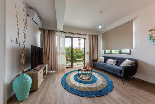 a living room with a couch and a table at 373 Wolmar Cosy and Modern Apartment- 200 metres from the Beach and Supermarkets and just next to Domaine de wolmar with views of deers and green natural park in Flic-en-Flac