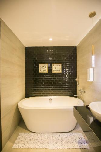 a white bath tub in a bathroom with a sink at Fati Boutique Hotel & Apartment in Vung Tau