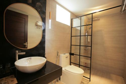 a bathroom with a sink and a toilet and a mirror at Fati Boutique Hotel & Apartment in Vung Tau