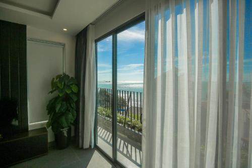 a room with a large window with a view of the ocean at Fati Boutique Hotel & Apartment in Vung Tau