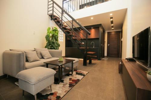 a living room with a couch and a staircase at Fati Boutique Hotel & Apartment in Vung Tau