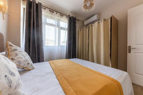 a small bedroom with a bed with a window at 373 Wolmar Cosy and Modern Apartment- 200 metres from the Beach and Supermarkets and just next to Domaine de wolmar with views of deers and green natural park in Flic-en-Flac