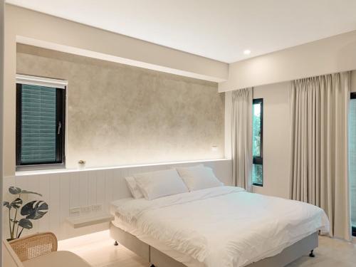 una camera con un letto bianco e una finestra di 如沐咖啡旅宿 a Xingjian
