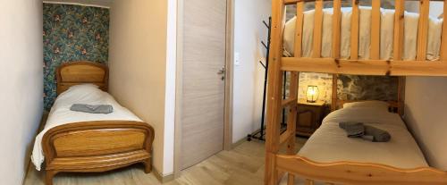 two beds in a room with a bunk bed at Le Gîte au bord de la Forêt in Monthermé