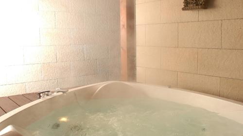 a bath tub filled with water in a bathroom at Hotel Allamanda大人の隠れ家リゾート in Nara