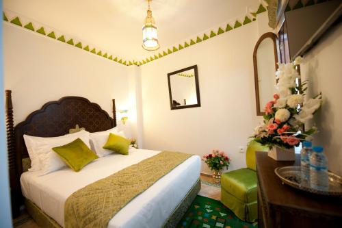a bedroom with a bed and a table and a mirror at Dar Yasmine in Tangier
