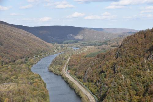 a river in the middle of a valley with trees at Le Gîte au bord de la Forêt in Monthermé