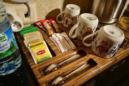 a wooden tray with cups and utensils on a counter at NOSTALJİ CAVE SUİT HOTEL in Nevşehir