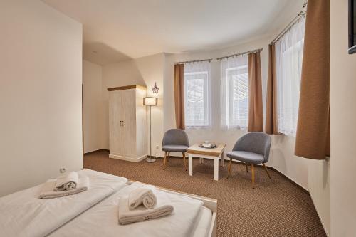 ヤンスケー・ラーズニェにあるPension Vartaのベッド2台、テーブルと椅子が備わるホテルルームです。