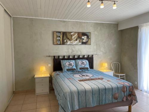 una camera con un letto con due tavoli e due lampade di Les Ondes - Grande Terrasse RdC Calme Parking Proche Plage a Antibes
