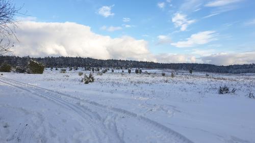 a snow covered field with a road in the distance at Ferienwohnung Ram 1 in Hermannsburg