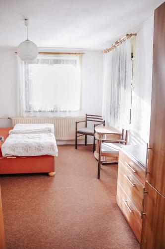 a bedroom with a bed and a chair and a table at Chalupa Bob a Bobek in Rokytnice v Orlických Horách