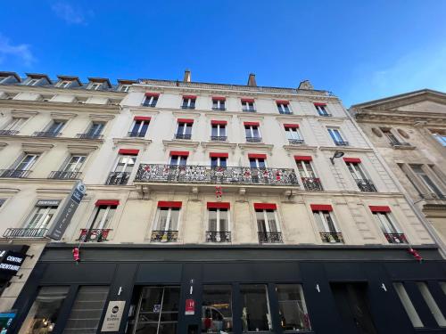 - un grand bâtiment blanc avec des portes et des fenêtres rouges dans l'établissement Best Western Empire Elysees, à Paris