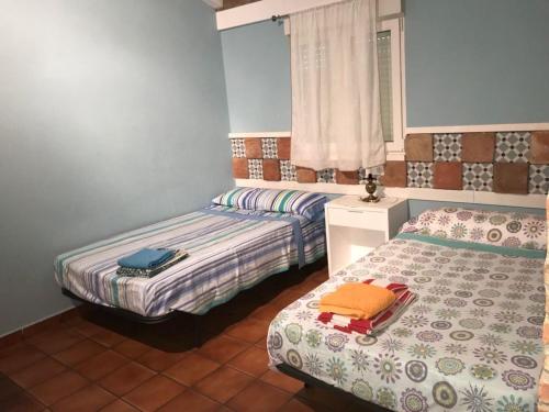 a bedroom with two beds and a window at La Casa del Muti in Campanario