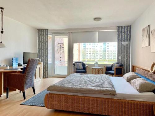 1 dormitorio con cama, escritorio y ventana en Trafalgar Apartment 133, en Cuxhaven