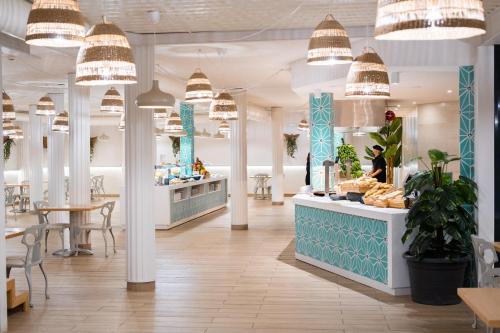 een winkel met tafels en stoelen en hanglampen bij Checkin Bungalows Atlántida in Los Cristianos