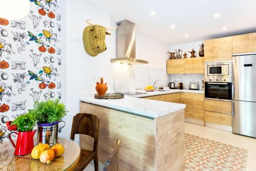 a kitchen with a counter and a table with fruits at Genteel Home Romanilla in Granada