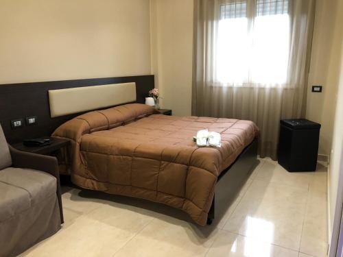 ein Schlafzimmer mit einem großen Bett und einem Fenster in der Unterkunft Grand Hotel Royal in Pompei